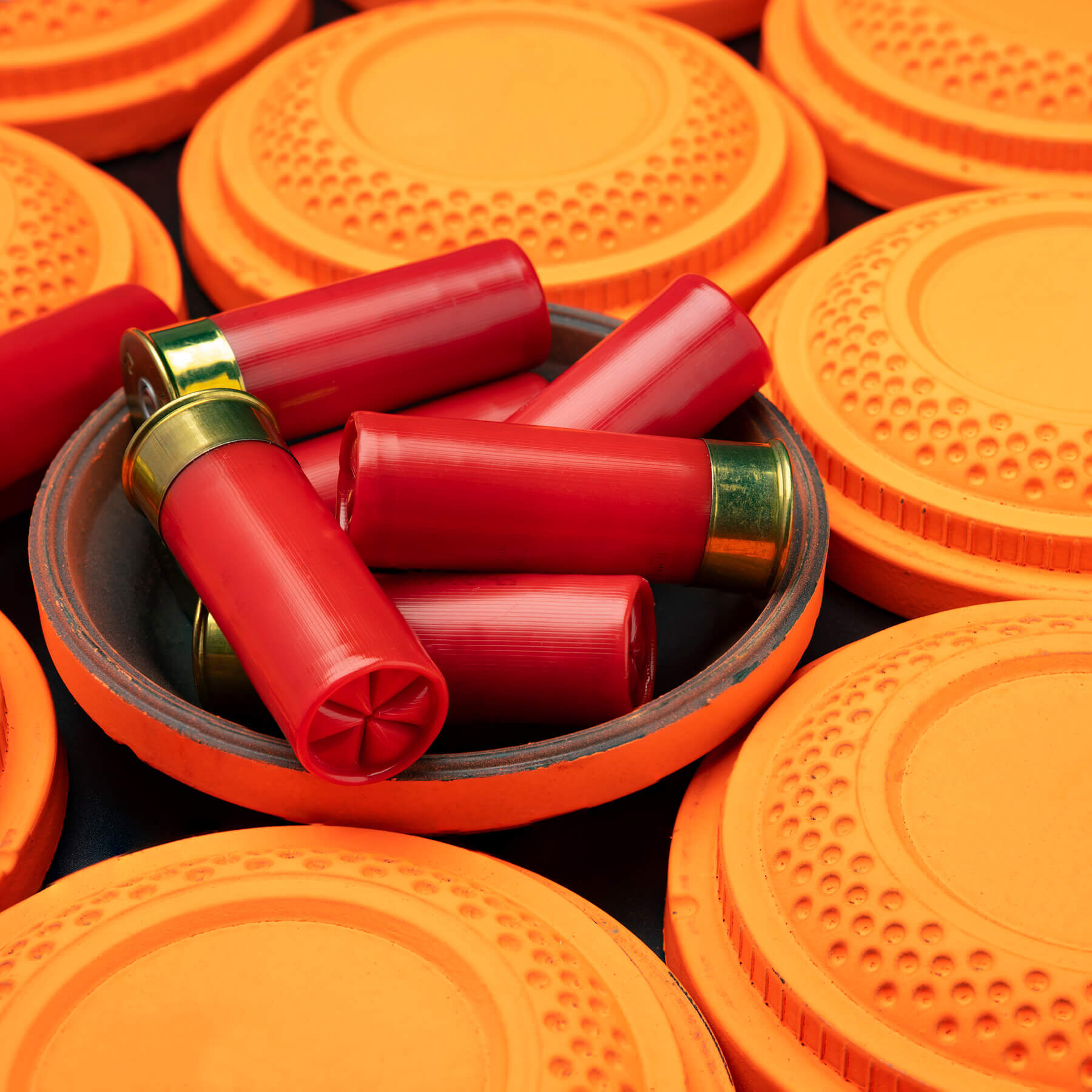 Clay disc flying targets and shotgun bullets on black background ,Clay Pigeon target